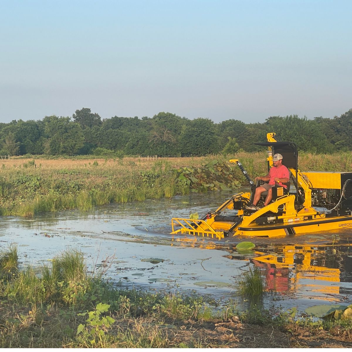 Weedoo boat shown cleaning moss from a pond in Paris, Texas